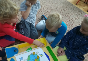 Dzieci grają w grę ucząc się segregowania odpadów